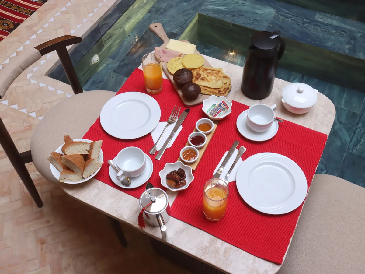 Petit-déjeuner marocain dressé au bord de la piscine du patio