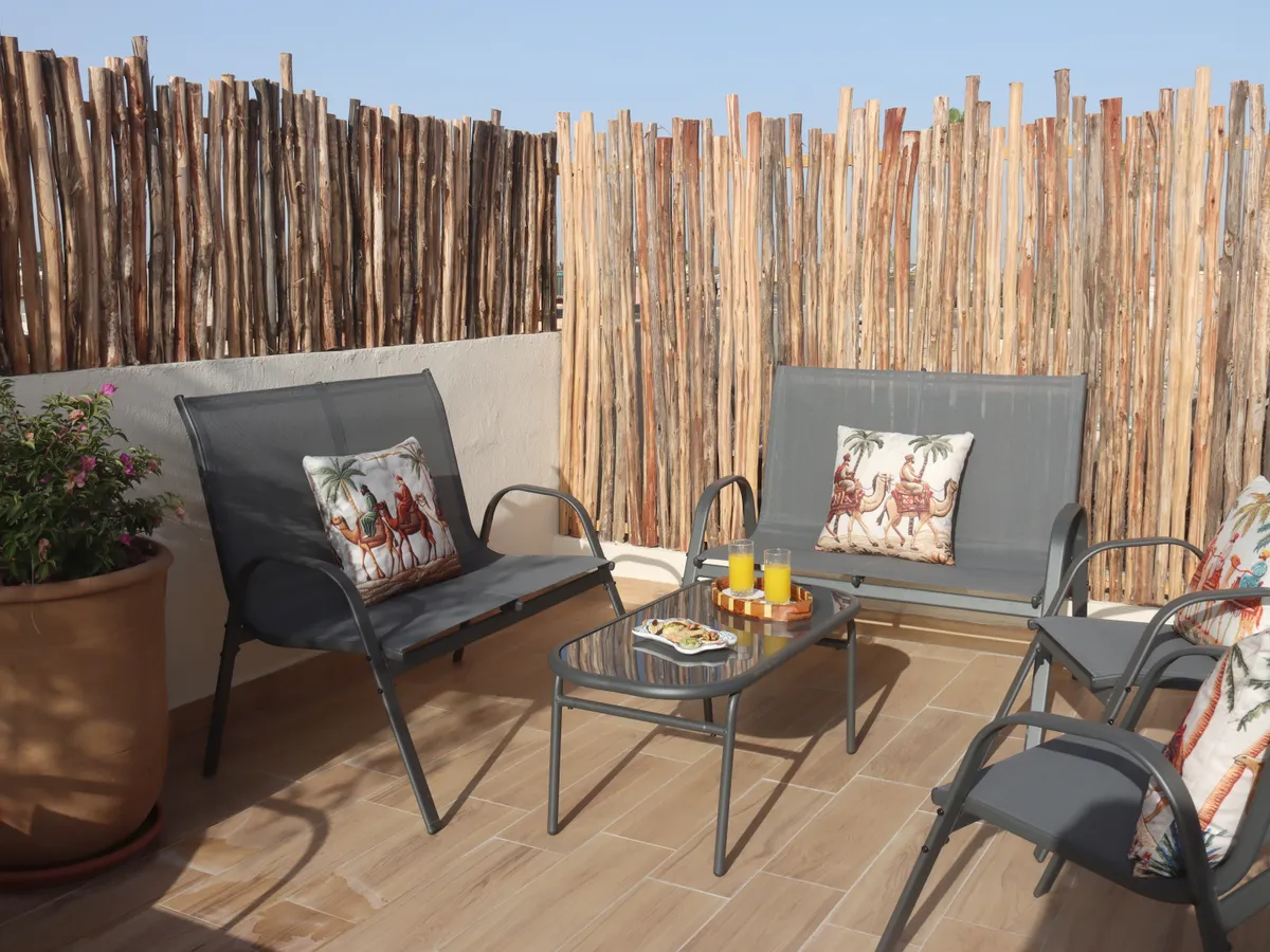 Coin salon sur la terrasse avec oliviers en pot
